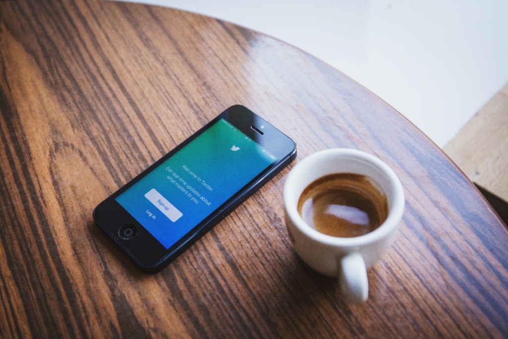 Phone on a table on Twitter with coffee